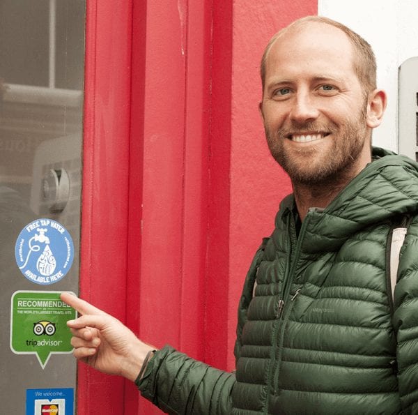 Rob Greenfield pointing at a refill station